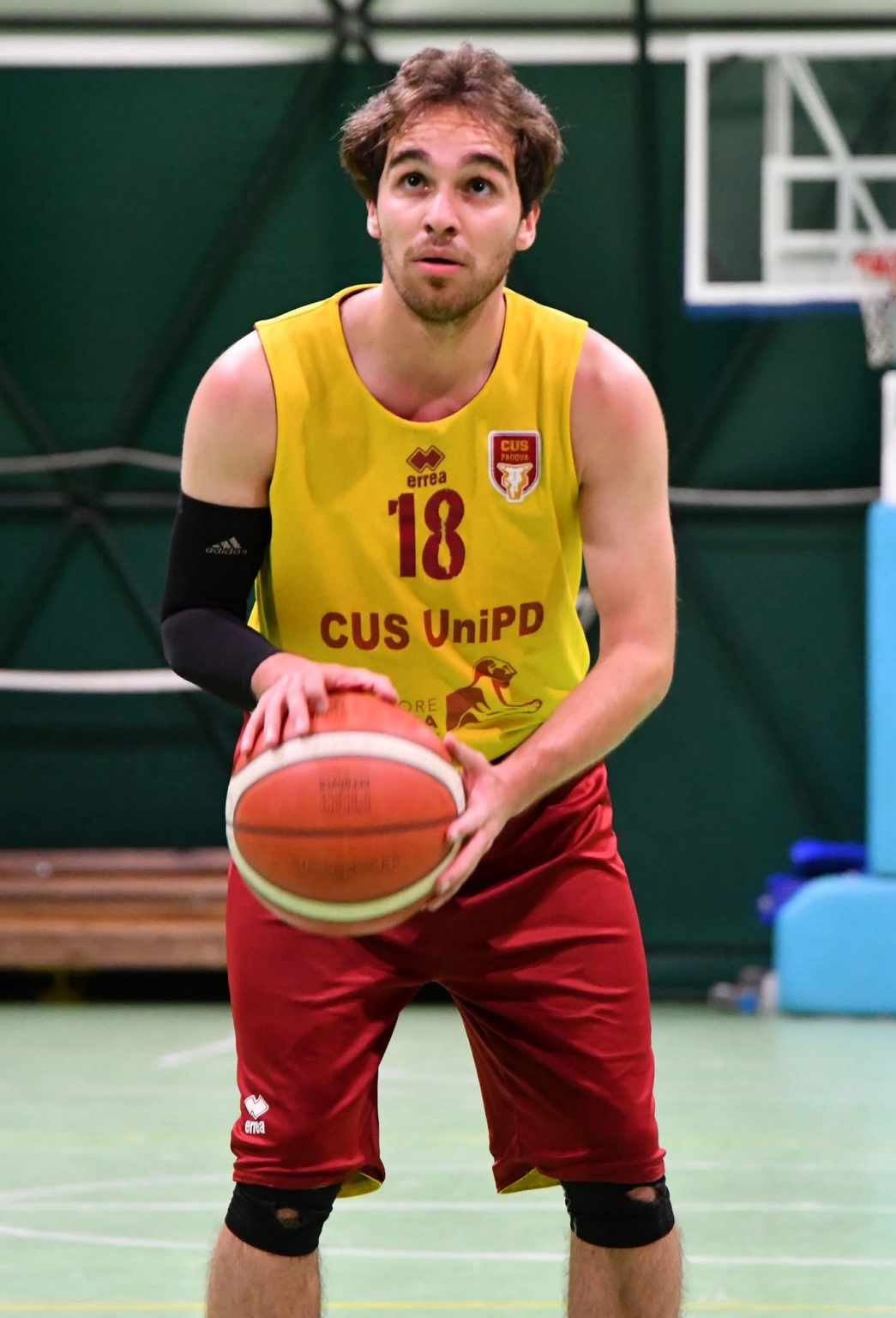 Captain Cem holding the basketball at the free-throw line, wearing number 18.