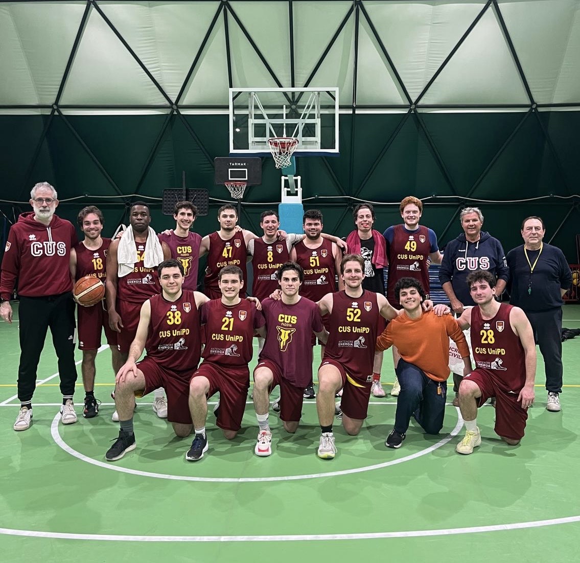 CUS Padova players and coaches posing together after a match in amaranto kit.